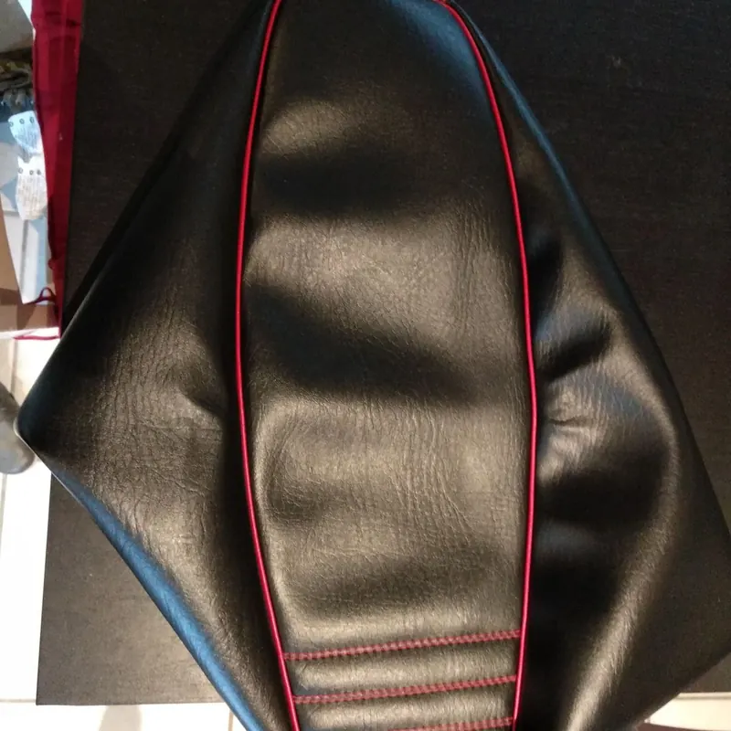 Détail de la selle noire avec surpiqûres et jonc rouge